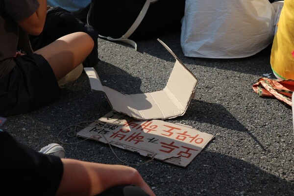 7일 오후 서울 강남에서 907기후정의행진이 열렸다. 참가자가 종이 상자 조각으로 만들어 온 피켓이 바닥에 누워 있다. 사진=최나영 기자