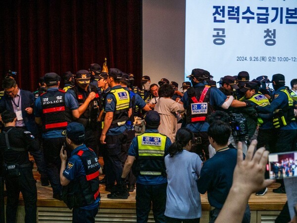 경남기후위기비상행동 등 환경단체 회원들이 26일 오전 정부세종청사에서 열린 11차 전력수급기본계획 공청회에서 시작에 앞서 "핵발전소 수명연장, 신규 건설 결사반대" 등을 주장하며 단상을 점거하다 경찰과 충돌했다. 사진=11차 전력수급기본계획 백지화 네트워크