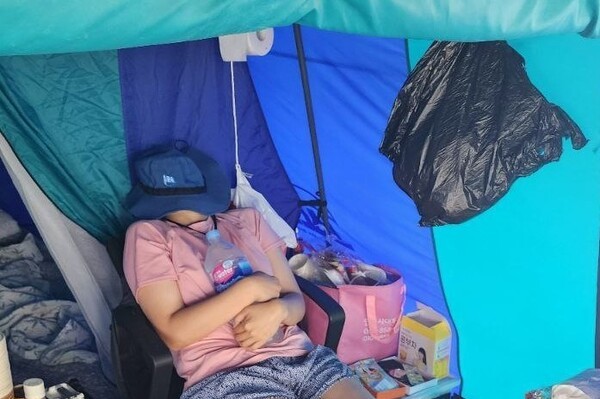 한국옵티칼하이테크 해고 노동자 박정혜씨가 지난 6월 구미공장 옥상에서 고공농성을 하던 중 얼음물을 안고 더위를 식히고 있다. 사진=금속노조